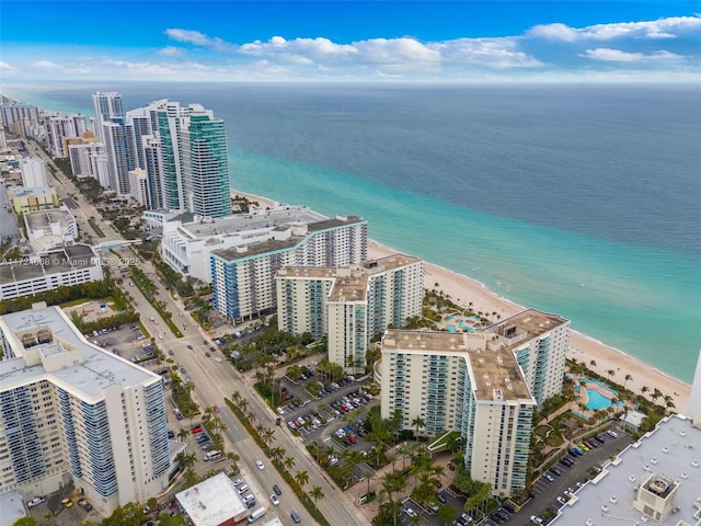 birds eye view of property with a water view and a beach view