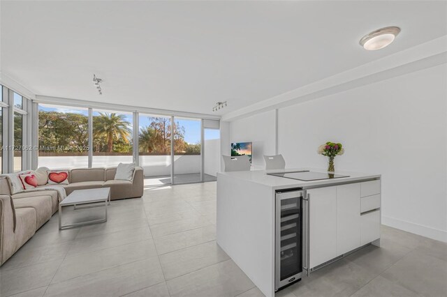 kitchen with white cabinetry, wine cooler, black electric cooktop, and expansive windows