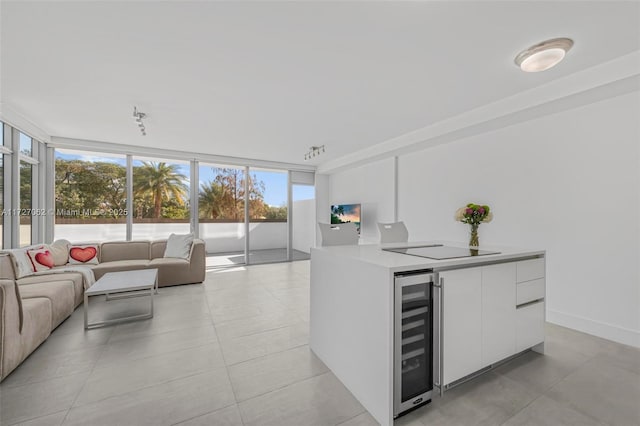 kitchen featuring expansive windows, white cabinetry, beverage cooler, and black electric cooktop