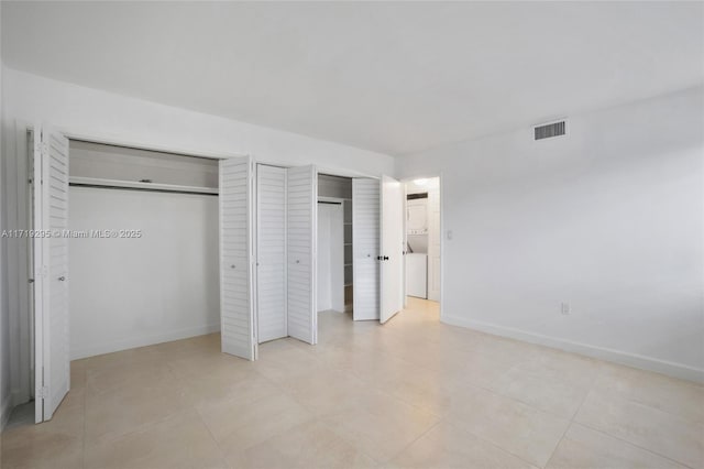 unfurnished bedroom with baseboards, visible vents, and multiple closets