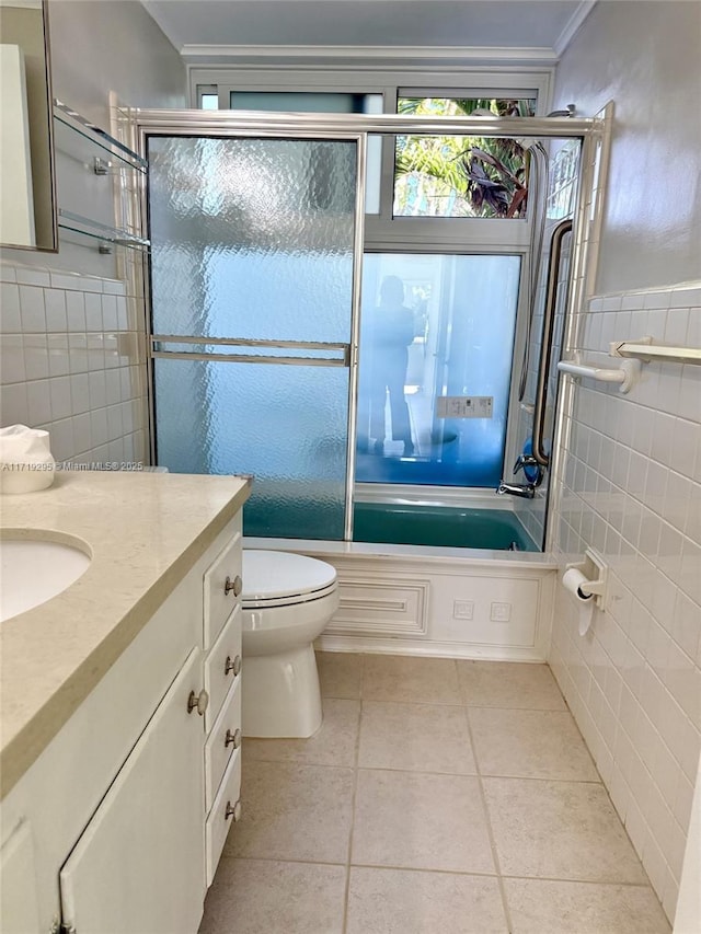 full bathroom featuring enclosed tub / shower combo, toilet, vanity, tile walls, and tile patterned floors