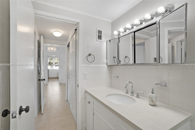 bathroom with crown molding, tile walls, visible vents, vanity, and tile patterned floors