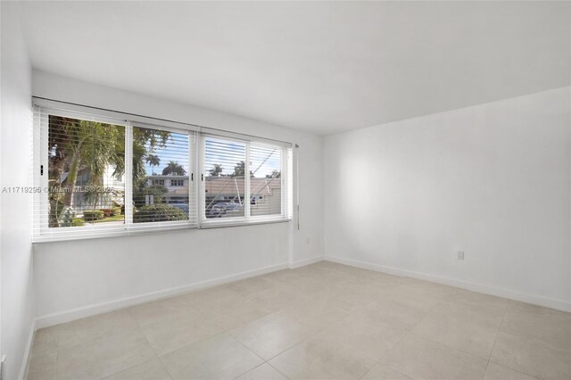 180 Isle Of Venice Dr Unit 105, Fort Lauderdale, FL 33301 - spare room featuring baseboards and light tile patterned flooring