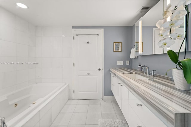 bathroom with vanity, tile patterned flooring, and tiled tub