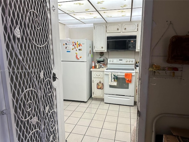 kitchen featuring white appliances, white cabinets, and light tile patterned flooring