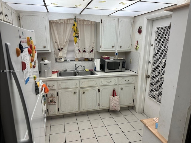 kitchen with sink, light tile patterned floors, and refrigerator