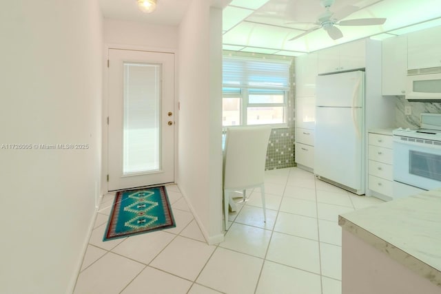 kitchen with white appliances, ceiling fan, backsplash, white cabinets, and light tile patterned flooring