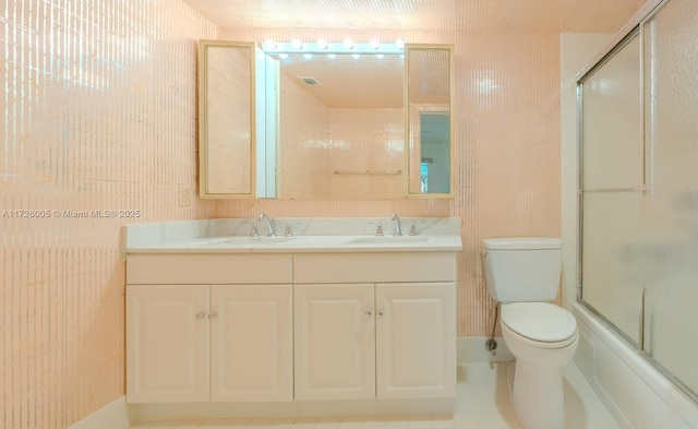 full bathroom with vanity, tile patterned flooring, shower / bath combination with glass door, and toilet