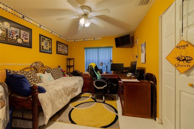 bedroom with ceiling fan, light tile patterned floors, and a textured ceiling