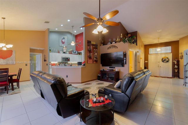 tiled living room featuring high vaulted ceiling and ceiling fan with notable chandelier