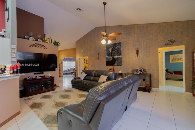 tiled living room with ceiling fan and vaulted ceiling