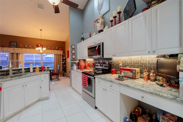 kitchen with decorative light fixtures, white cabinets, and stainless steel appliances