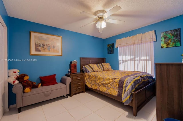 bedroom with a textured ceiling, ceiling fan, and light tile patterned floors