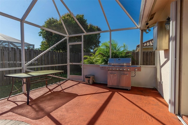 view of patio featuring glass enclosure and area for grilling