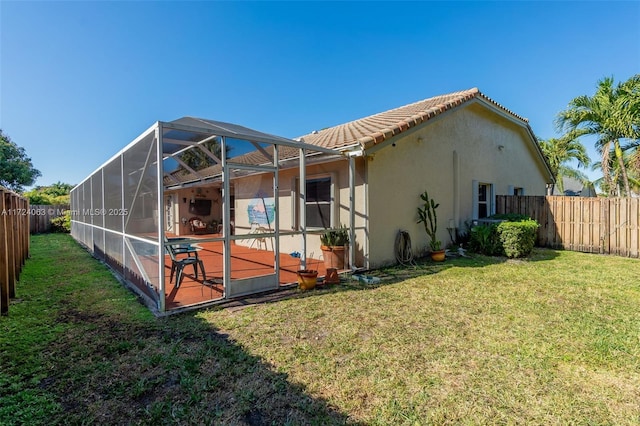 rear view of house with a lanai, a lawn, and a patio