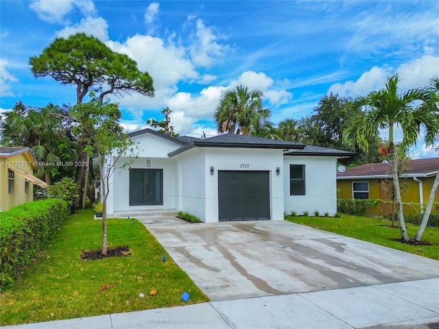 view of front of property featuring stucco siding, an attached garage, concrete driveway, and a front yard