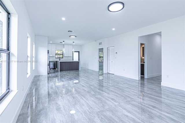 unfurnished living room with recessed lighting, baseboards, and visible vents