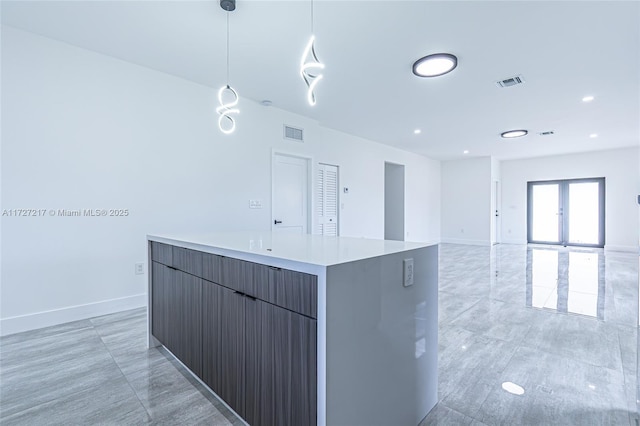 kitchen featuring light countertops, decorative light fixtures, modern cabinets, and visible vents