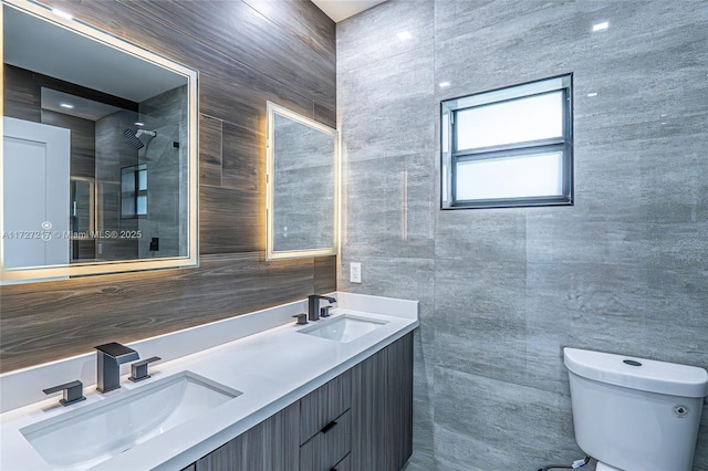 bathroom featuring a tile shower, toilet, tile walls, and a sink