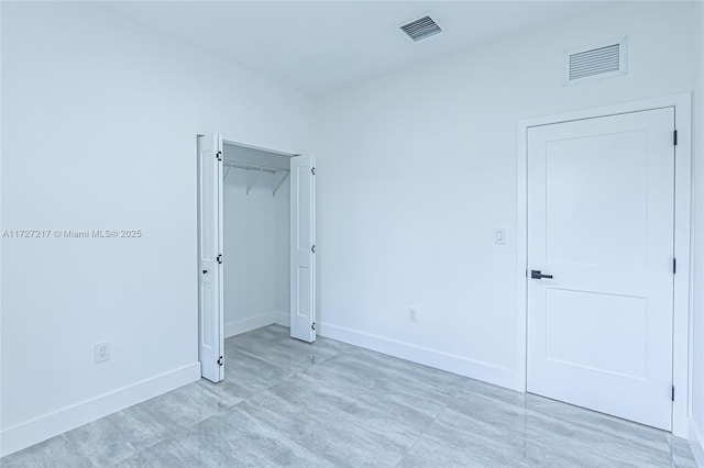 unfurnished bedroom featuring baseboards, visible vents, and a closet