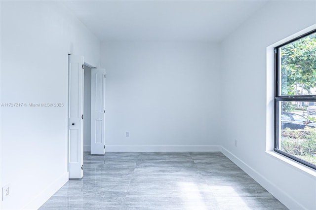 unfurnished room featuring baseboards and a healthy amount of sunlight