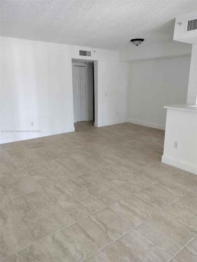 unfurnished room with a textured ceiling