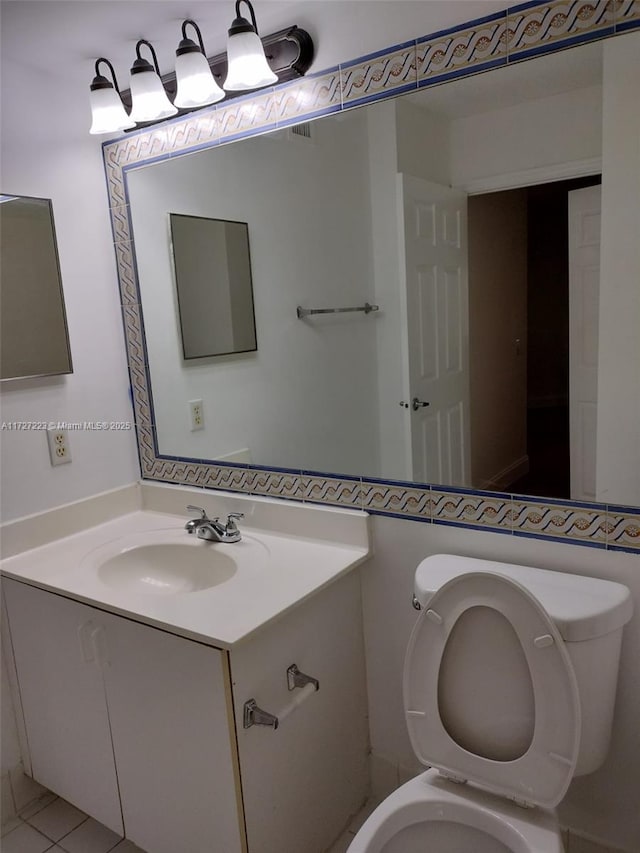 bathroom featuring toilet, vanity, and tile patterned flooring