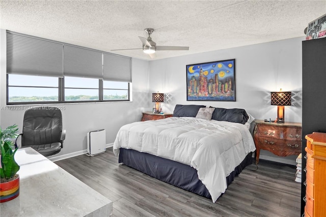 bedroom with a textured ceiling, ceiling fan, and dark hardwood / wood-style flooring