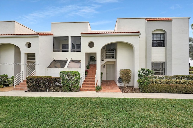 mediterranean / spanish home with a front yard