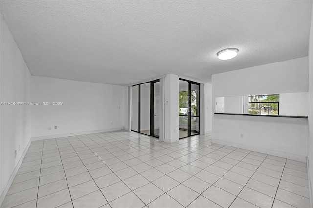 unfurnished room with light tile patterned floors and a textured ceiling