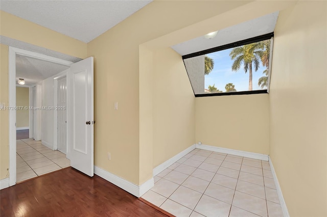 tiled spare room with a textured ceiling