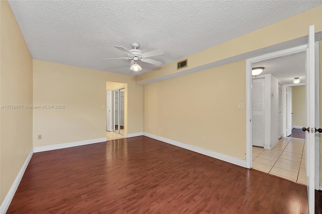 empty room featuring ceiling fan, light hardwood / wood-style floors, and a textured ceiling