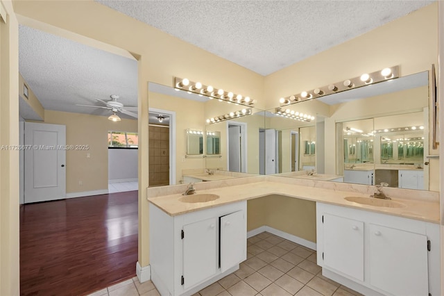 bathroom featuring a textured ceiling, tile patterned flooring, vanity, a shower, and ceiling fan