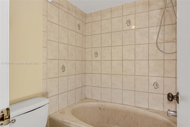 bathroom featuring toilet and tiled shower / bath combo