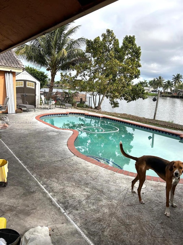 view of swimming pool with a water view and a patio area