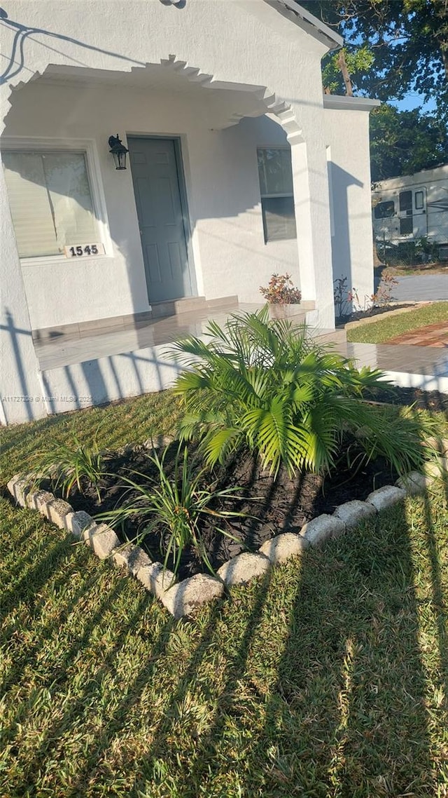 view of exterior entry featuring a lawn