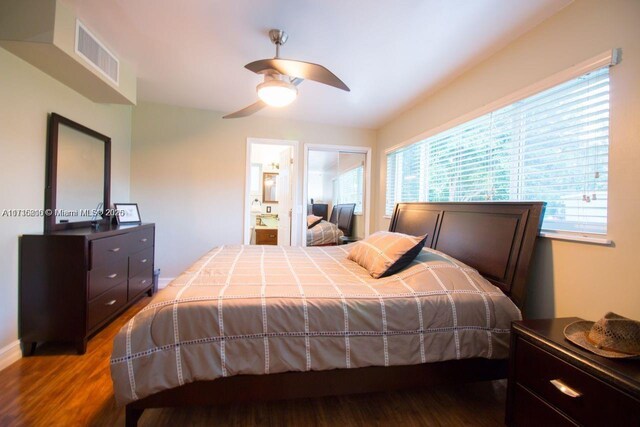 bedroom with ceiling fan, wood-type flooring, connected bathroom, and multiple windows