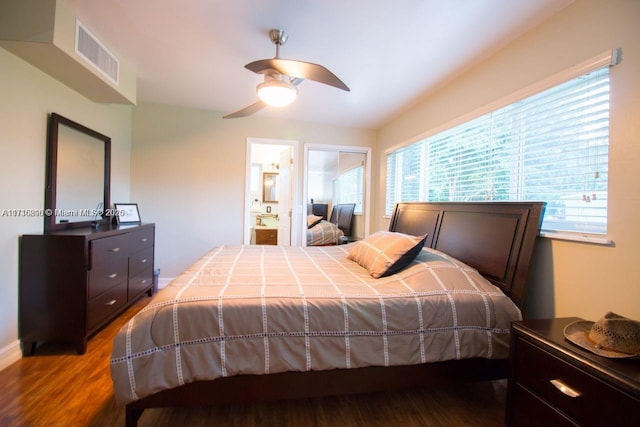 bedroom featuring ceiling fan, multiple windows, connected bathroom, and hardwood / wood-style flooring