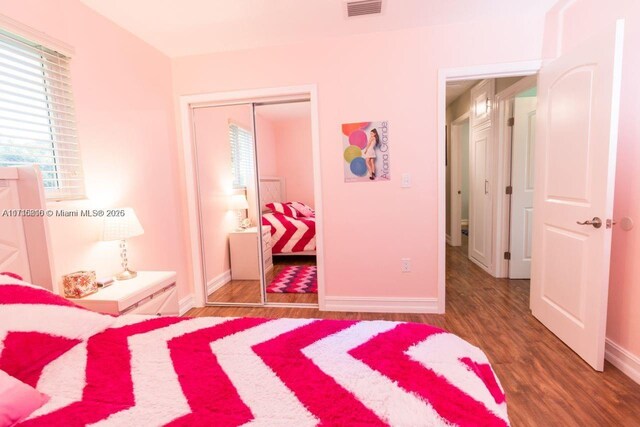 bedroom featuring dark wood-type flooring and a closet