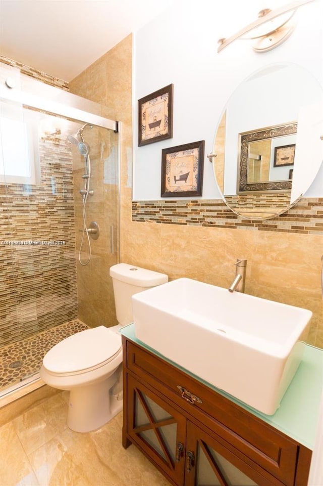 bathroom featuring tile walls, toilet, vanity, and walk in shower