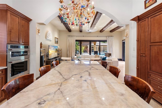 dining area with beamed ceiling and a chandelier