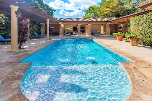 view of swimming pool featuring pool water feature, ceiling fan, a pergola, and a patio area