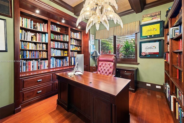 office space with hardwood / wood-style flooring, built in shelves, beamed ceiling, and an inviting chandelier