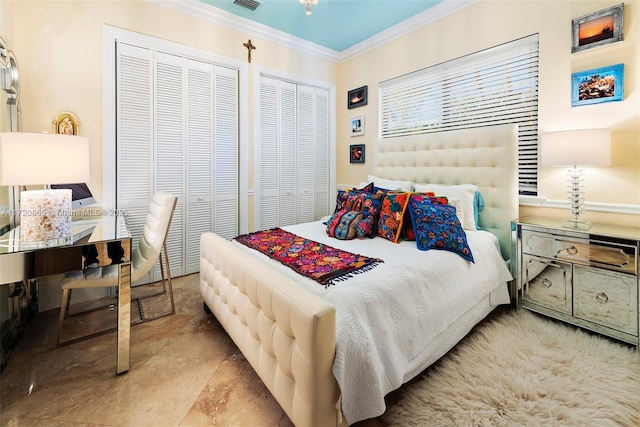 bedroom with crown molding and two closets