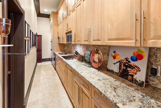 kitchen featuring light stone counters, sink, backsplash, and ornamental molding