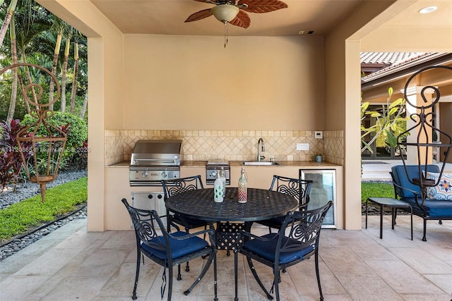 view of patio featuring exterior kitchen, sink, a grill, and ceiling fan