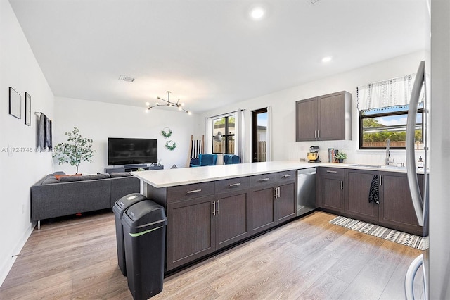 kitchen featuring light hardwood / wood-style floors, dark brown cabinets, dishwasher, and kitchen peninsula