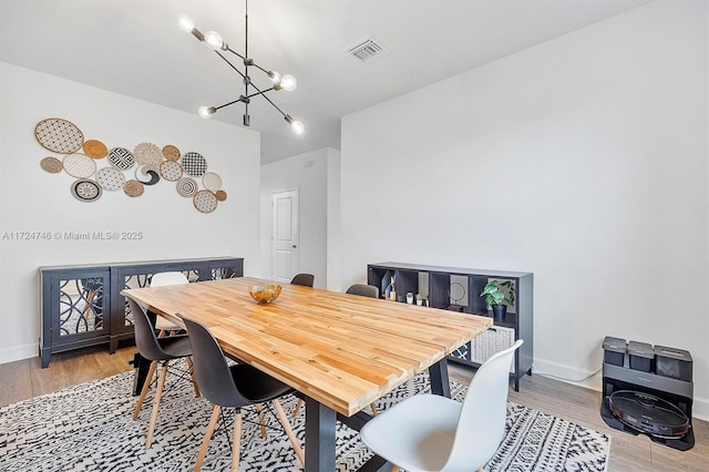 dining area with a chandelier and light hardwood / wood-style flooring