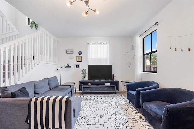 living room featuring wood-type flooring, an inviting chandelier, and a wealth of natural light