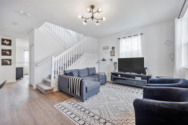 living room with light wood-type flooring and a notable chandelier